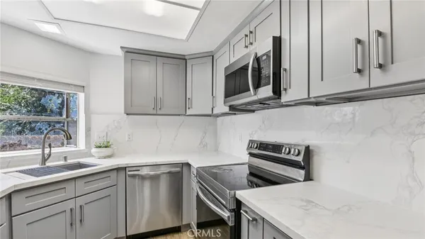 a kitchen with stainless steel appliances white cabinets and a sink