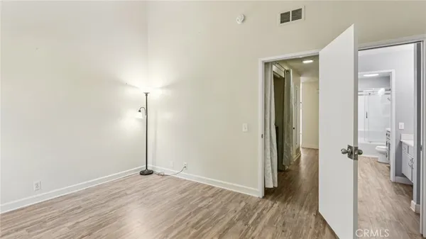 an empty room with wooden floor and a bathroom