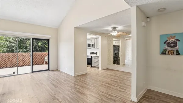 a view of a big room with wooden floor and windows