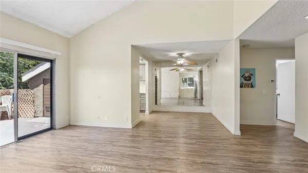 a view of a hallway with wooden floor and a living room