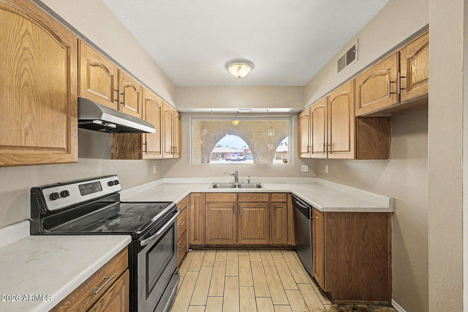 4007 West Mountain View Road Phoenix, AZ 85051 - Photo 12 of 31 a kitchen with stainless steel appliances granite countertop a sink stove and refrigerator