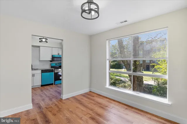a open kitchen with a large window a refrigerator and a dishwasher