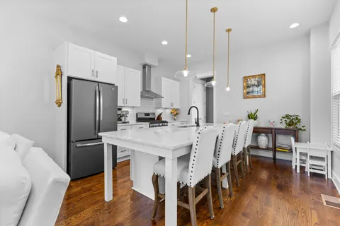 a kitchen with a table chairs and wooden floor