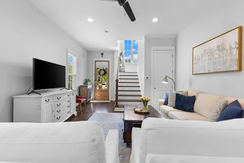 a living room with furniture kitchen view and a chandelier