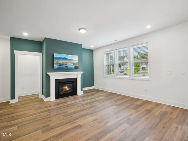 a view of empty room with wooden floor and fireplace
