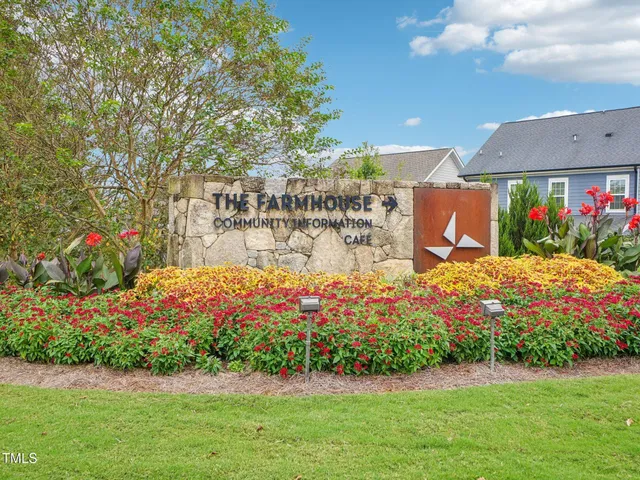 a front view of multi story residential apartment building with yard and parking space