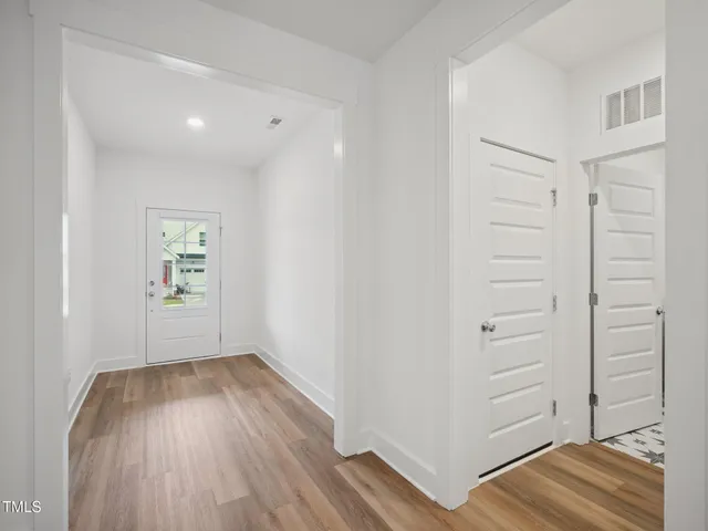 a kitchen with stainless steel appliances granite countertop a sink a stove a refrigerator and island with wooden floor