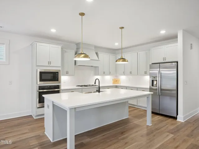 a kitchen with a stove a refrigerator and a sink