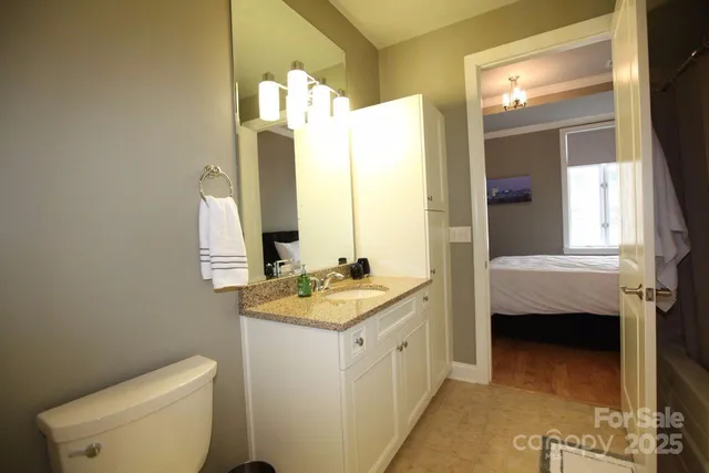 a en suite bathroom with a granite countertop sink and a mirror
