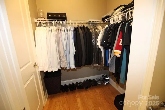 a view of walk in closet with clothes and shoes