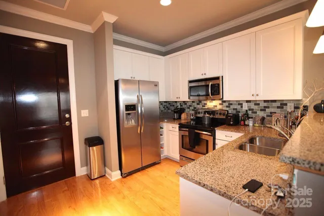 a kitchen with stainless steel appliances granite countertop a sink stove and refrigerator