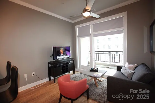 a living room with furniture a flat screen tv and a window