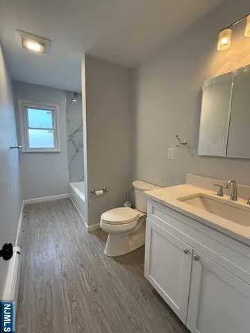 a bathroom with a sink mirror vanity and toilet