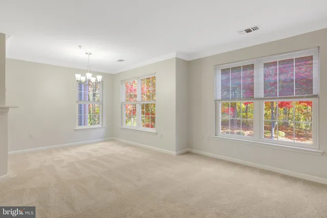 a view of an empty room with a chandelier fan