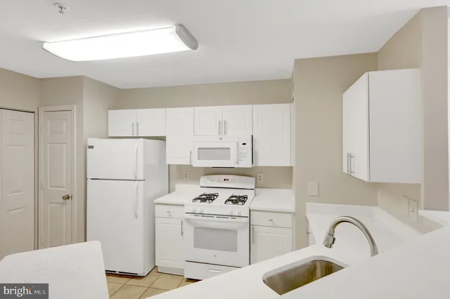a kitchen with white cabinets and appliances
