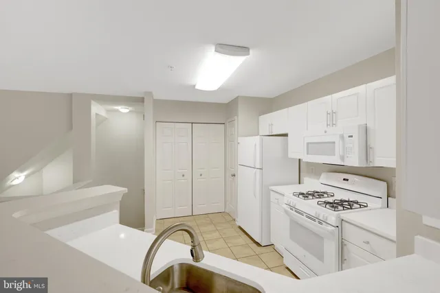 a kitchen with appliances a sink and cabinets