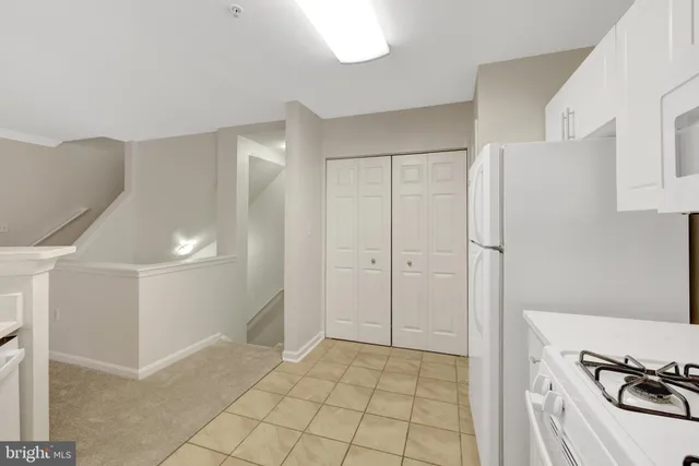 a view of an empty room with wooden floor and a cabinet