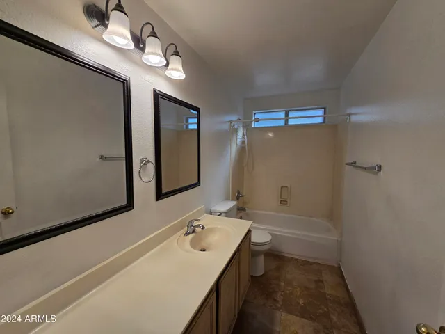 a bathroom with a sink a toilet and mirror