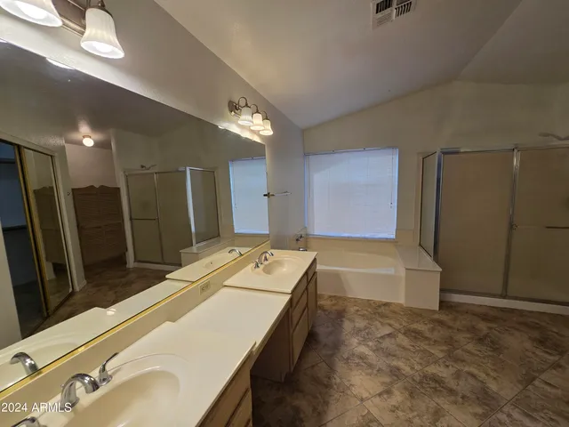 a spacious bathroom with a tub sink and a mirror