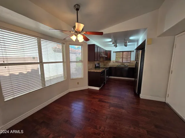 a view of a kitchen with a stove wooden floor and a ceiling fan