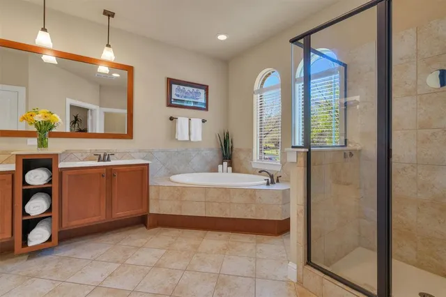 a spacious bathroom with a granite countertop sink a mirror and shower