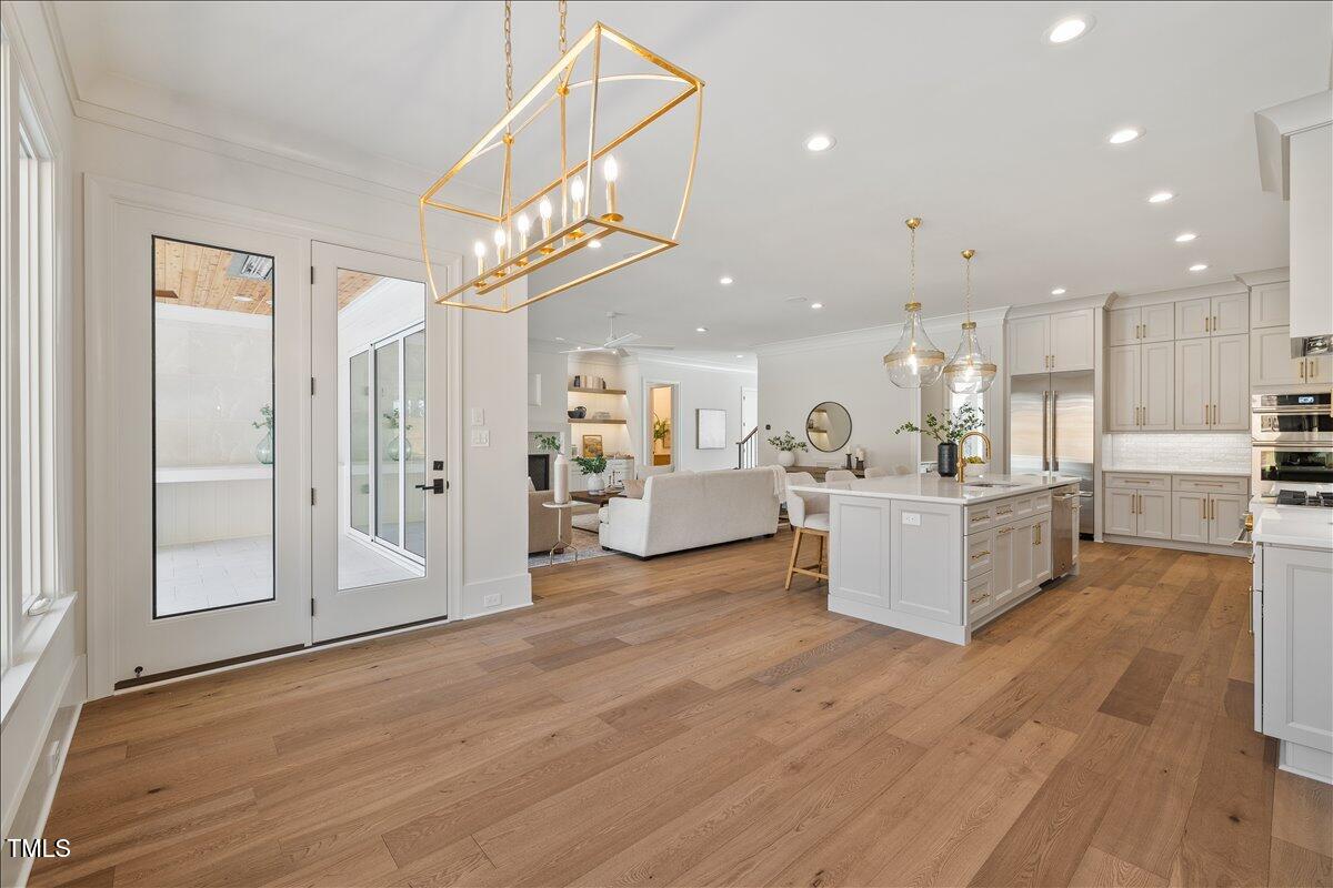 7516 Grist Mill Road Raleigh, NC 27615 - Photo 18 of 83 a view of a kitchen with kitchen island stainless steel appliances wooden floor and living room view