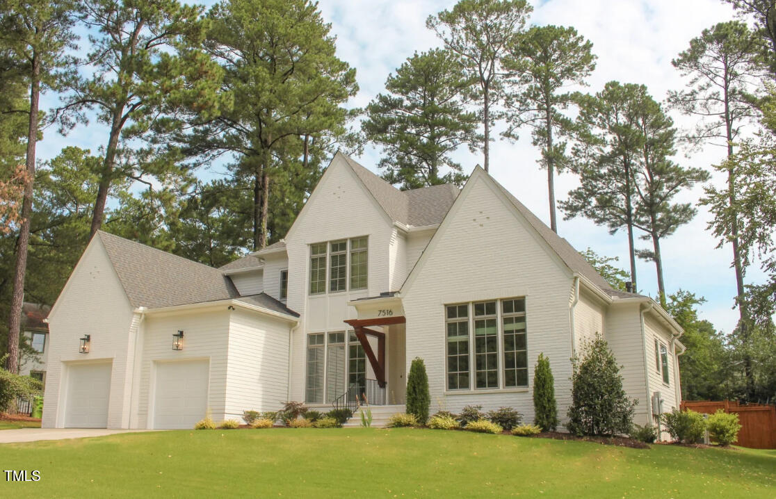 7516 Grist Mill Road Raleigh, NC 27615 - Photo 2 of 83 a view of a white house next to a yard with palm trees