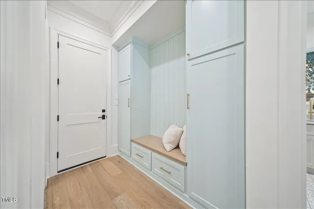 an empty room with wooden floor chandelier and windows