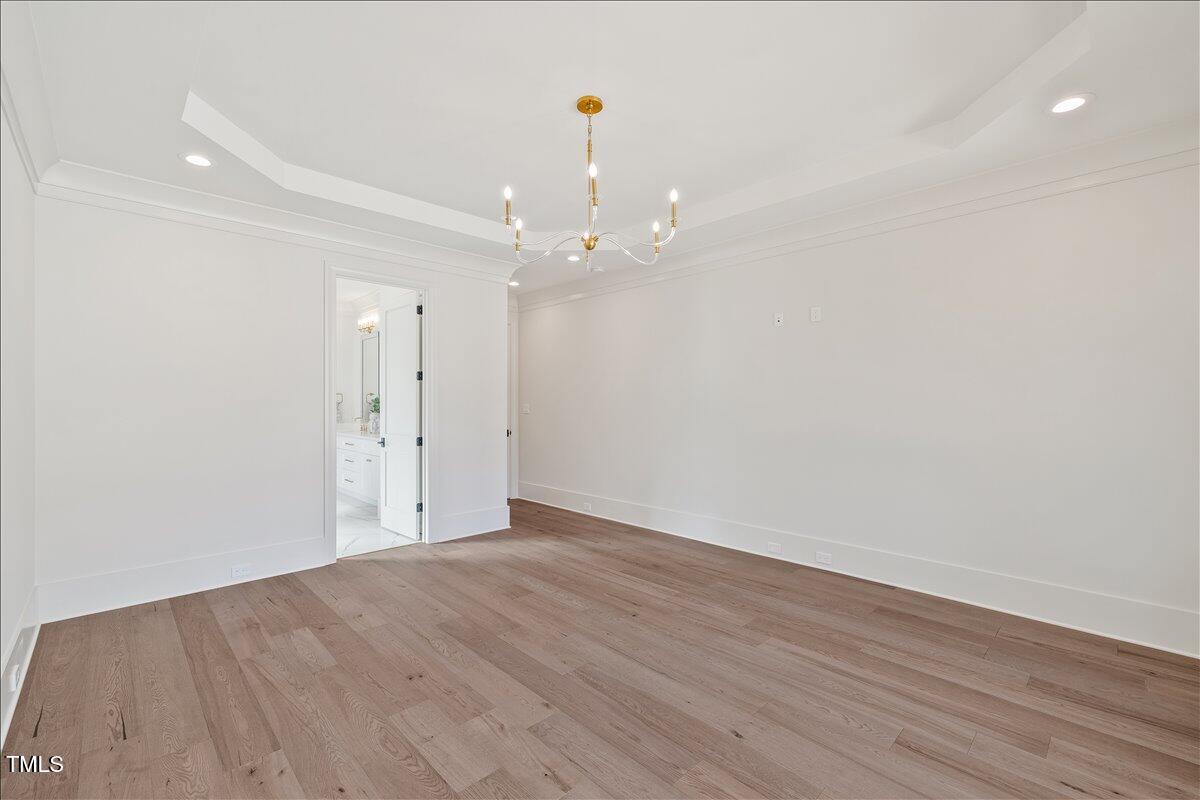 7516 Grist Mill Road Raleigh, NC 27615 - Photo 39 of 83 a view of an empty room with wooden floor and white walls