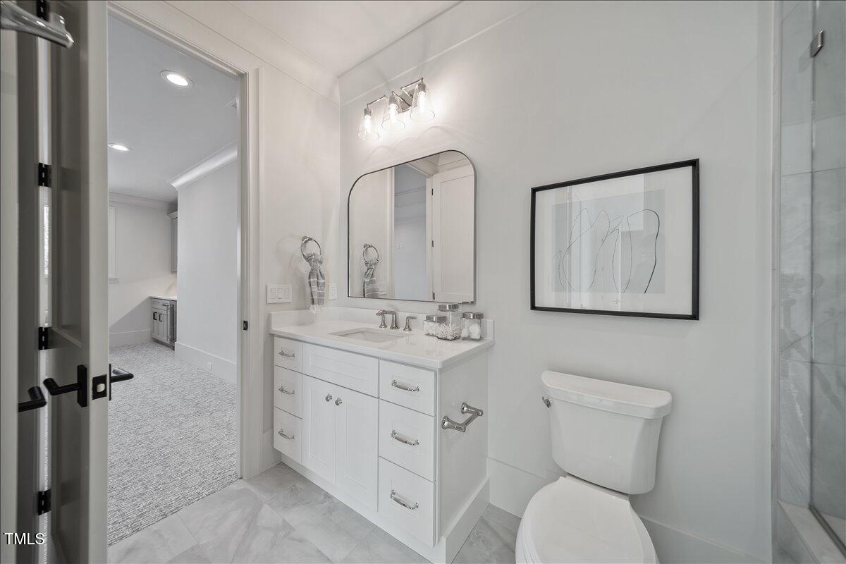 7516 Grist Mill Road Raleigh, NC 27615 - Photo 52 of 83 a bathroom with a toilet sink and mirror