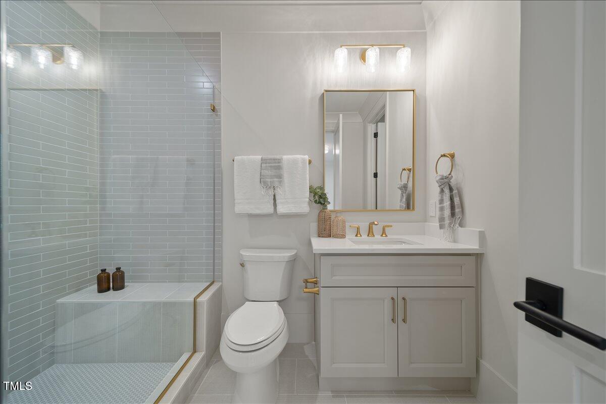 7516 Grist Mill Road Raleigh, NC 27615 - Photo 66 of 83 a bathroom with a granite countertop toilet a sink and a mirror