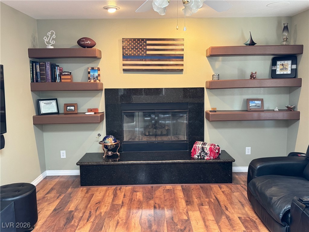 504 I Avenue Boulder City, NV 89005 - Photo 11 of 60 Living area featuring a tiled fireplace, dark wood-style floors, and a ceiling fan
