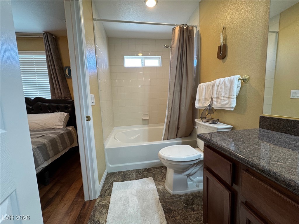 504 I Avenue Boulder City, NV 89005 - Photo 36 of 60 Bathroom with vanity, shower / bath combo with shower curtain, ensuite bathroom, and a textured wall