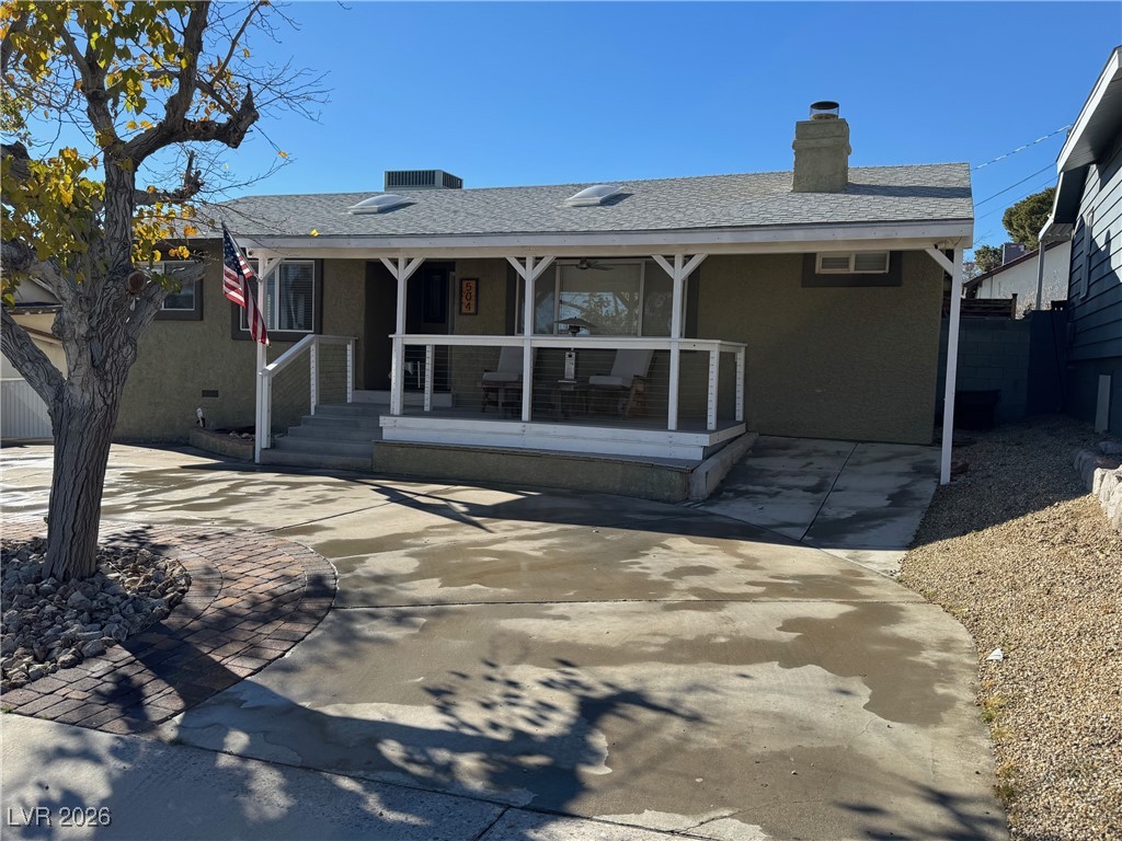504 I Avenue Boulder City, NV 89005 - Photo 4 of 60 View of front facade featuring a porch, a chimney, roof with shingles, and stucco siding