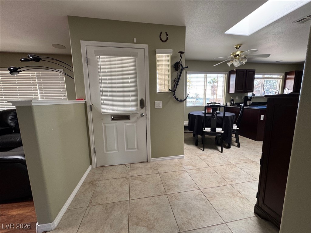 504 I Avenue Boulder City, NV 89005 - Photo 7 of 60 Foyer featuring a skylight, light tile patterned floors, ceiling fan, and a textured ceiling