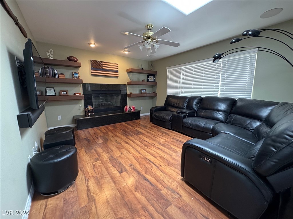 504 I Avenue Boulder City, NV 89005 - Photo 9 of 60 Living area with light wood-style floors, a tiled fireplace, and ceiling fan