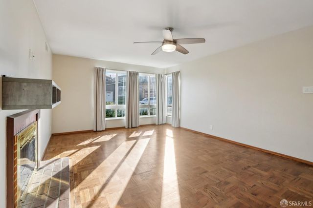 a view of an empty room with a fireplace and a window