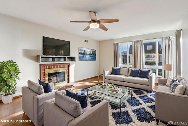 a living room with furniture a fireplace and a flat screen tv