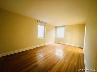69 Harney Road, Unit 6B Scarsdale, NY 10583 - Photo 4 of 11 a view of an empty room with wooden floor and a window