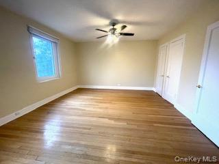 69 Harney Road, Unit 6B Scarsdale, NY 10583 - Photo 6 of 11 a view of an empty room with wooden floor and a window