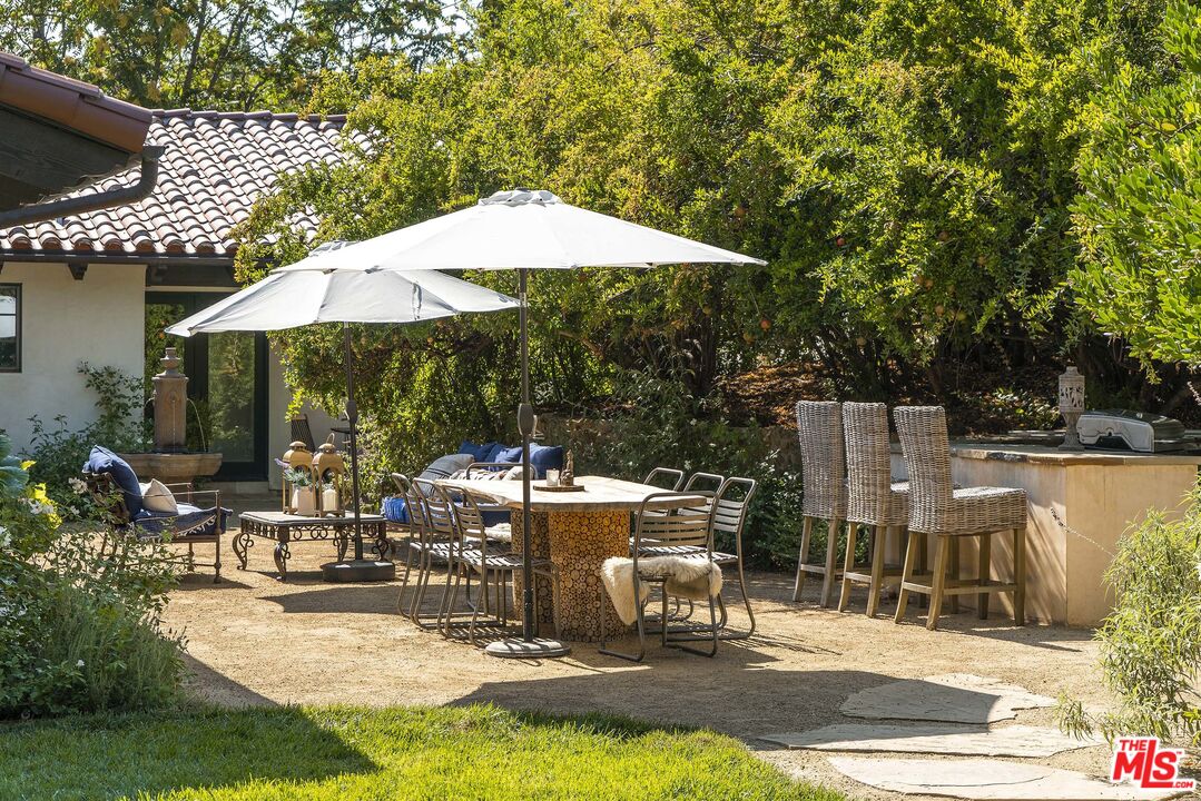 2251 Cold Canyon Road Calabasas, CA 91302 - Photo 42 of 47 a view of a patio with chairs under an umbrella
