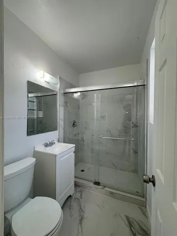 a bathroom with a toilet a sink and shower