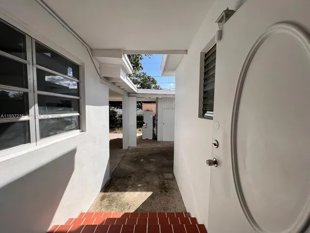a view of a hallway with wooden floor and entryway