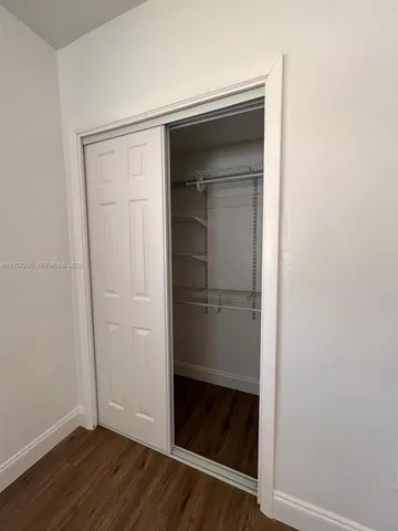 a view of walk in closet with wooden floor