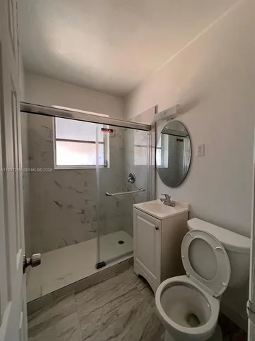 a bathroom with a toilet a sink and mirror