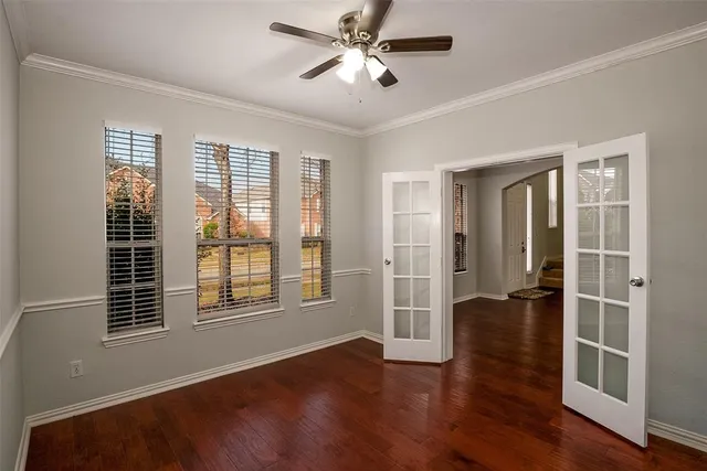a view of an empty room with a window and wooden floor