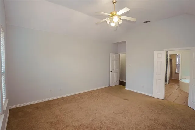 a view of an empty room with a ceiling fan