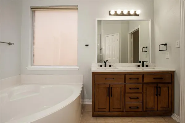a bathroom with a tub sink and mirror