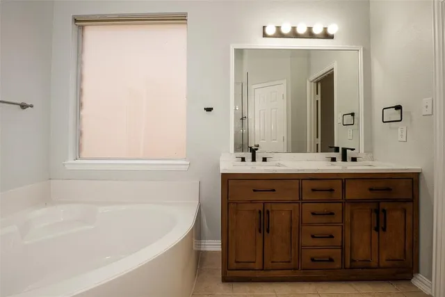 a bathroom with a tub sink and mirror