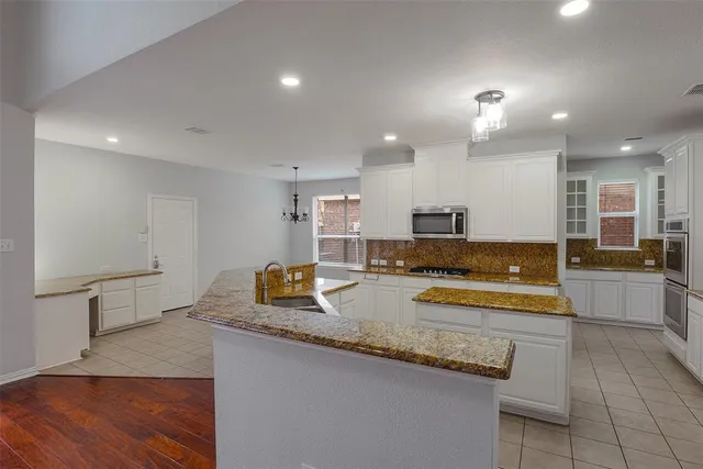 a large kitchen with a large counter top appliances and cabinets
